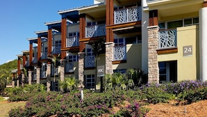 A multi-story hotel with balconies, a sign reading "FDC", and a number "24" on the building. - Family Friendly 3BR Villa in Paradise- Saturday March 26- Sat., April 4, 2026 (St. John)