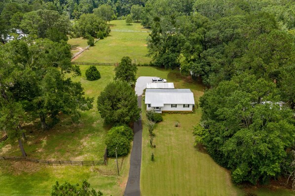 An aerial view of a house surrounded by dense trees and a well-maintained lawn. - Fairhope 3BR house. 4min to Grand Hotel, 7min to Dwntown Fhope, 44min to Gulf (Fairhope)