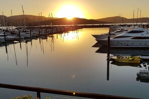 A marina with boats docked at sunset.