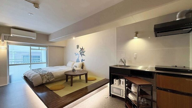 A modern hotel room with a bed, bedside table, and a small kitchen area including a sink and microwave. - ORIGAMINN 303 by b hotel - 5 mins PeacePark (Hiroshima City)