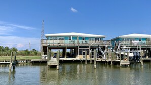 Une propriété située au bord de l’eau, dotée d’un quai, d’un bateau et d’un bâtiment avec un balcon.