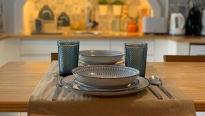 A dining table with two plates, two glasses, and cutlery set. - Modern and romantic house with large garden to relax (Ponta Delgada)