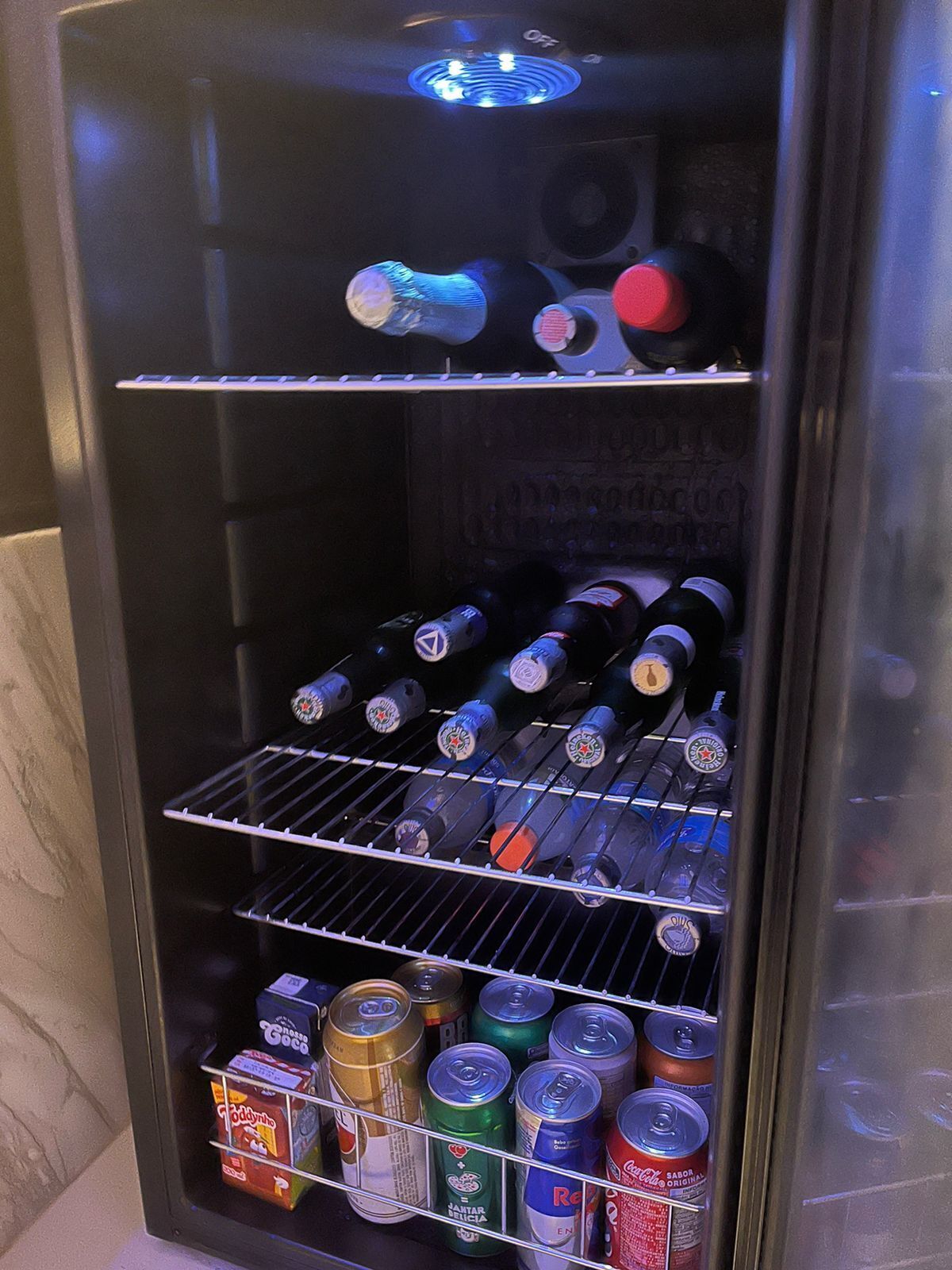 A vending machine stocked with various beverages including bottled water, beer, and canned drinks.