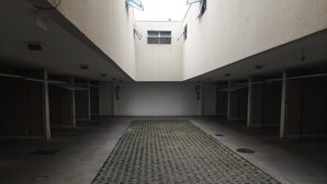 Un amplio atrio con suelo estampado, varias puertas y tragaluces.