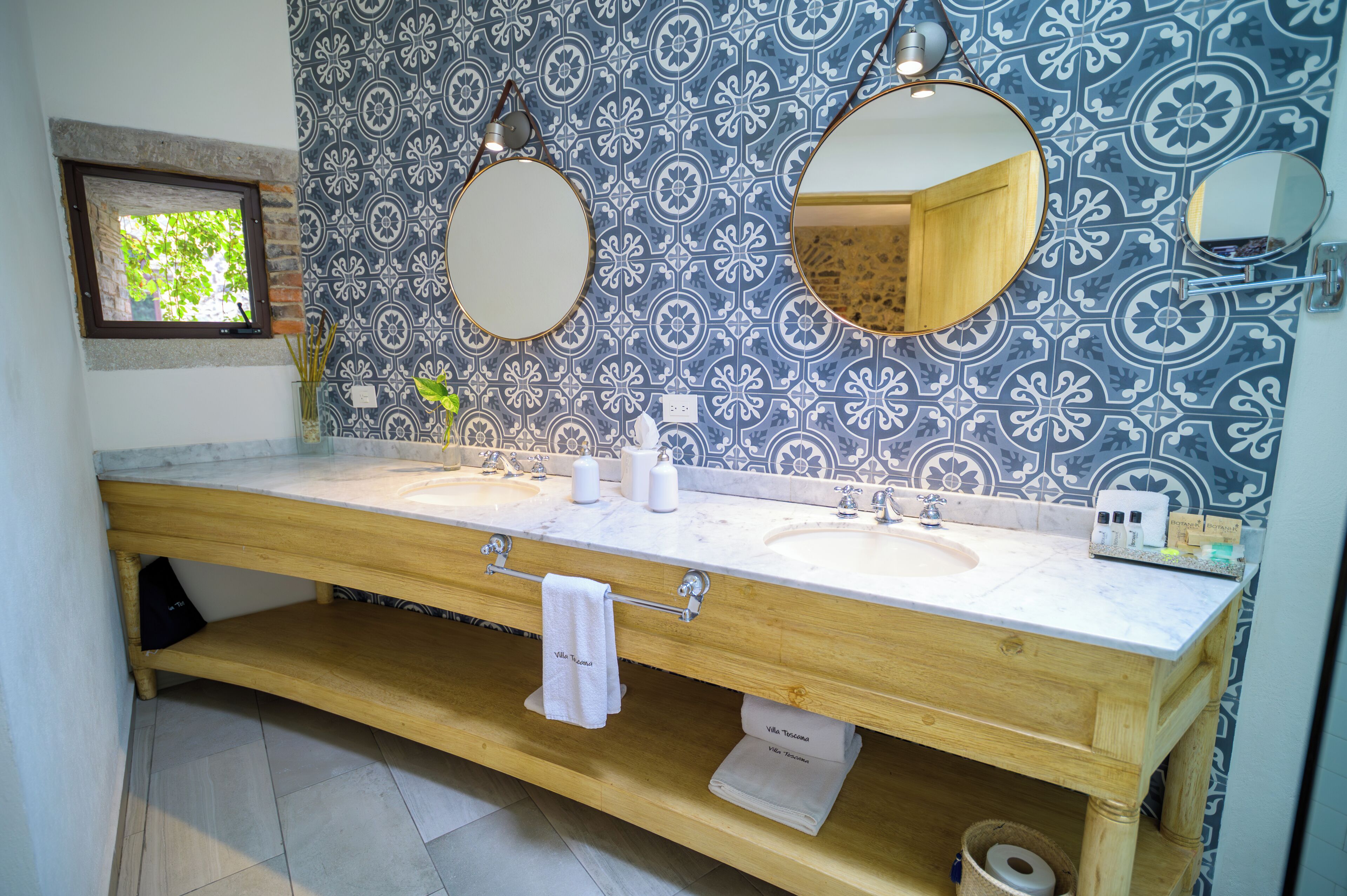 A bathroom with two sinks, a mirror, and a window.