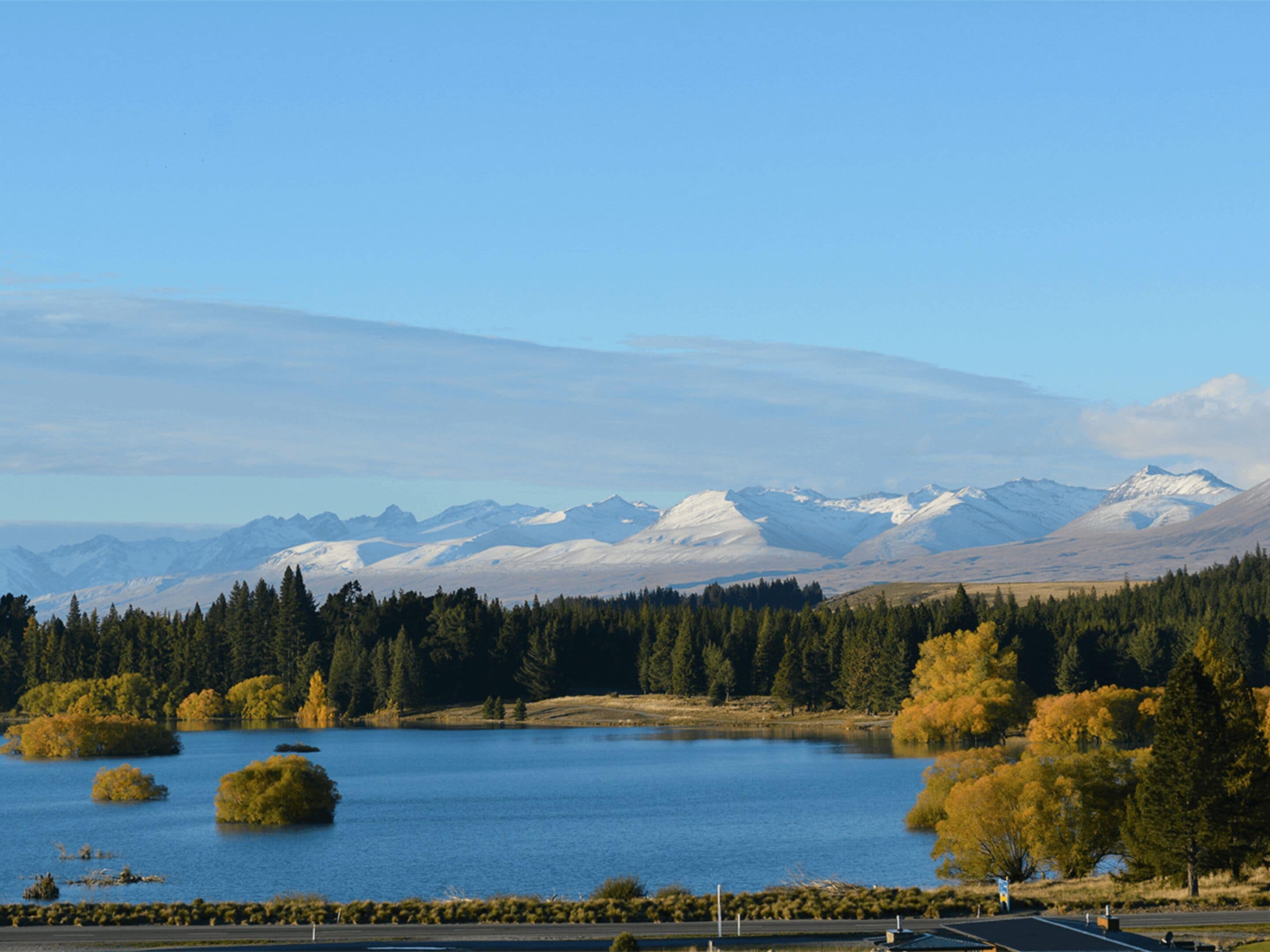 Un lago rodeado de montañas y árboles.