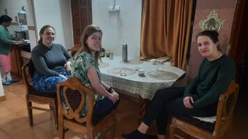 Un comedor con una mesa redonda, sillas y una persona de fondo.