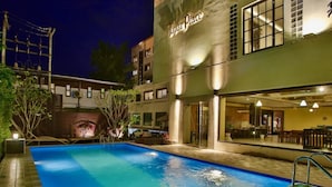 A swimming pool adjacent to a building with a sign reading "Tapac Place". - Tapae Place Hotel (Chiang Mai)