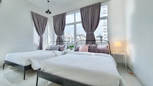 A modern hotel room with two beds, large windows with curtains, a ceiling fan, and a bedside table with a lamp. - Teiw Family Homestay at Skypod Residence Puchong (Puchong)