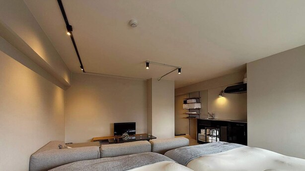 Een moderne hotelkamer met een groot bed, een televisie, een bureau met een lamp en een open haard.
