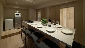 Une cuisine moderne dotée d’un îlot central, de tabourets de bar, d’un four à micro-ondes et d’une bouteille de vin.