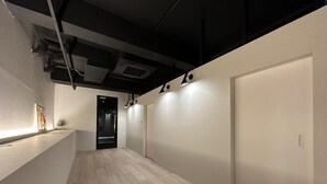 Ein Korridor mit Holzboden, weißer Wand und einer Tür am Ende.