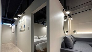 Ein modernes Hotelzimmer mit Bett, einer Couch und einem großen Spiegel.