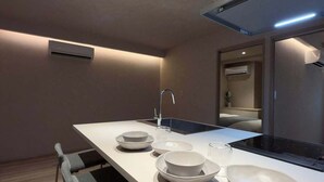 A modern kitchen with a central island, built-in appliances, and a minimalist design. - Renovated Double Bunk Bed & 2-Bath｜near Peace Park (Hiroshima City)