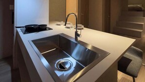 A modern kitchen with a stainless steel sink, a stove, and a sleek faucet. - Renovated Double Bunk Bed & 2-Bath｜near Peace Park (Hiroshima City)