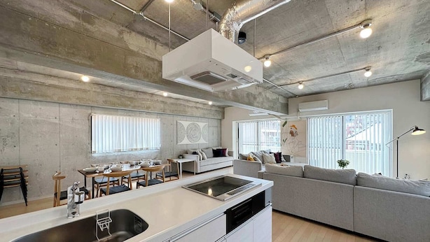 Une cuisine moderne dotée d’un îlot central, d’appareils électroménagers intégrés et d’un coin repas avec un canapé.