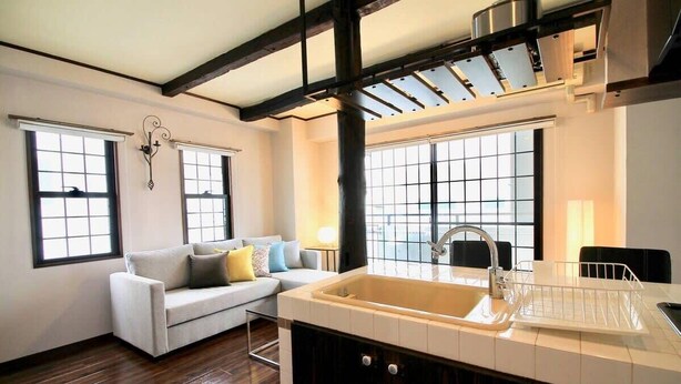 A modern kitchen with a large island, a built-in sink, and a window overlooking the city. - Next to Peace Park, Convenient Central Stay P61 (Hiroshima City)