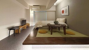 A modern hotel room with a bed, bedside table, TV, and a framed artwork on the wall. - ORIGAMINN 503 by b hotel - 5 mins PeacePark (Hiroshima City)