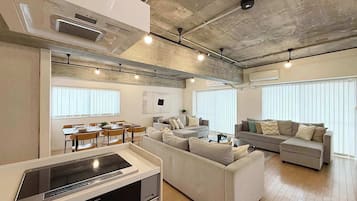 A modern living space with a kitchen, dining area, and seating area.