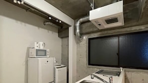 Un angolo cottura attrezzato con lavandino, forno a microonde e frigorifero.