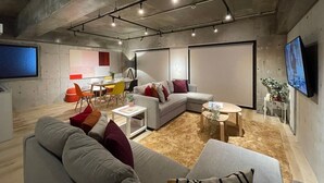Un soggiorno moderno con un divano ad angolo grigio, un tavolino da caffè e una TV fissata al muro.