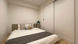 Una camera da letto moderna con un letto grande, un comodino con una lampada e una porta scorrevole per l'armadio.