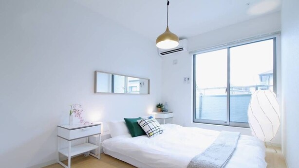 Une chambre à coucher moderne avec un grand lit, une table de chevet, un bureau et une fenêtre donnant sur l’eau.