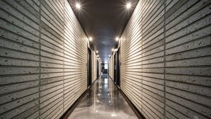 A corridor with a reflective floor and walls lined with evenly spaced lights. - Stay Month Hotel (Goyang)
