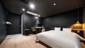 A modern hotel room with a large bed, a desk, and a chair. - Stay Month Hotel (Goyang)