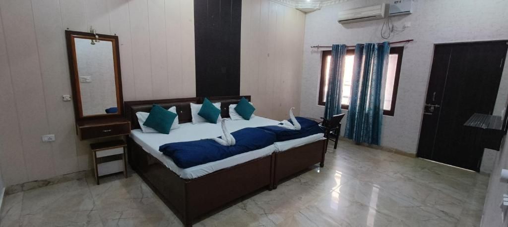 Un dormitorio con una cama, un espejo, un armario y una ventana con cortinas.