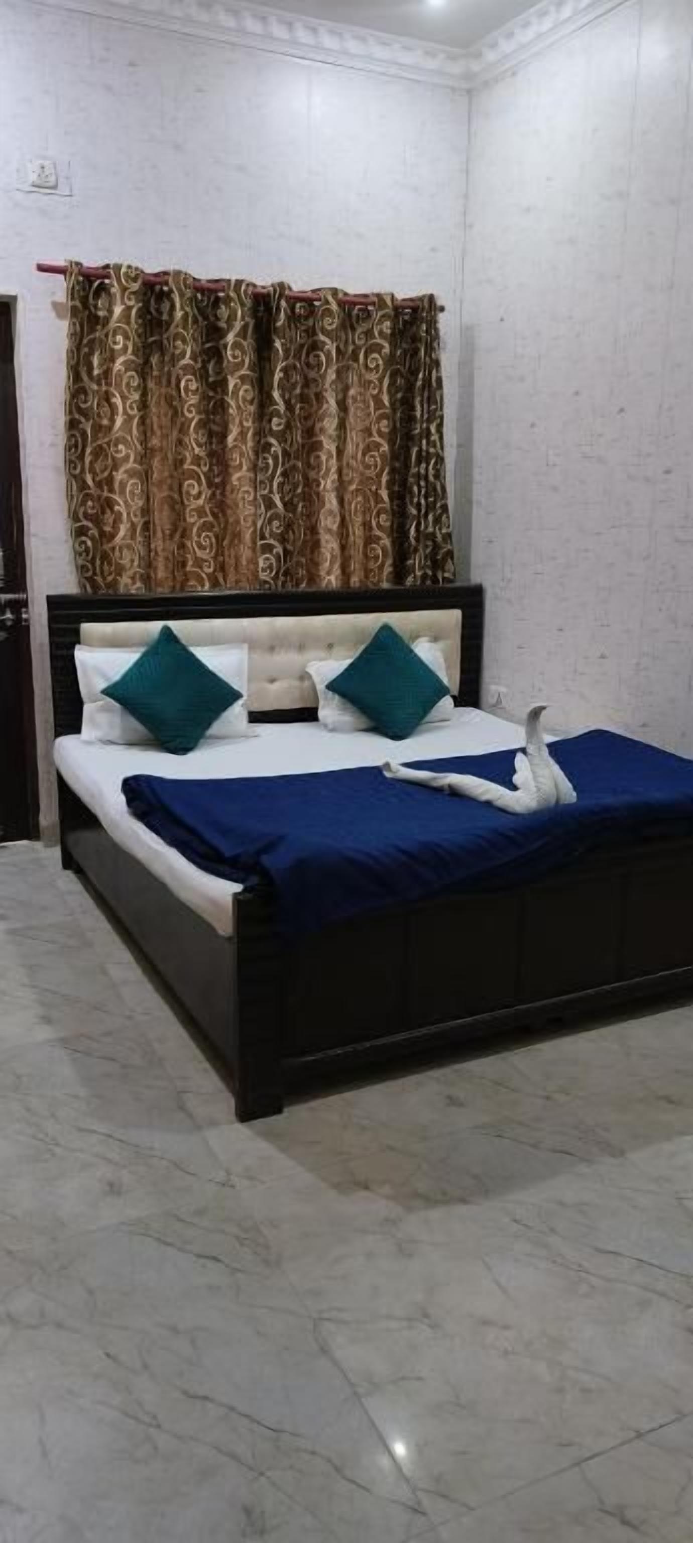 A bedroom with a bed, curtains, and a tiled floor.
