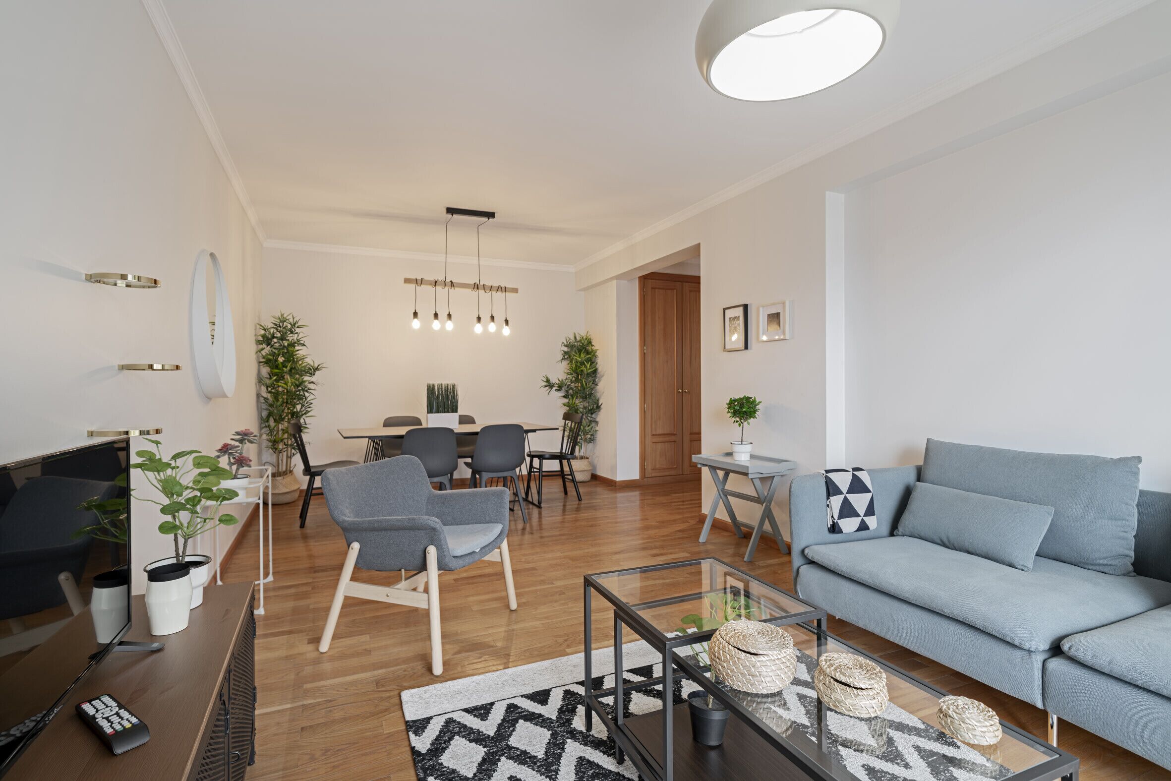 A modern living room with a sofa, chairs, a coffee table, and a TV.