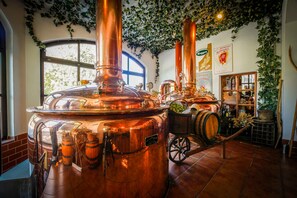 Een koper brouwerij met grote tanks, vaten en een kar.