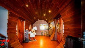 A wooden interior hallway with a rustic aesthetic, including a wooden door with a 'Welcome' sign, a decorative figure, and a tiled floor. - Brewery Gasthof Zwönitz, owner Dominik Naumann - Double room (Zwönitz)