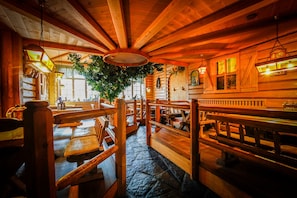 A rustic wooden interior with benches and tables, a large tree, and a stone floor. - Brewery Gasthof Zwönitz, owner Dominik Naumann - Double room (Zwönitz)