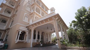 Un edificio de varios pisos con balcones ornamentales y un acceso cubierto.