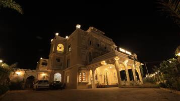 A large, ornate building with multiple levels and a central entrance, surrounded by well-maintained landscaping.