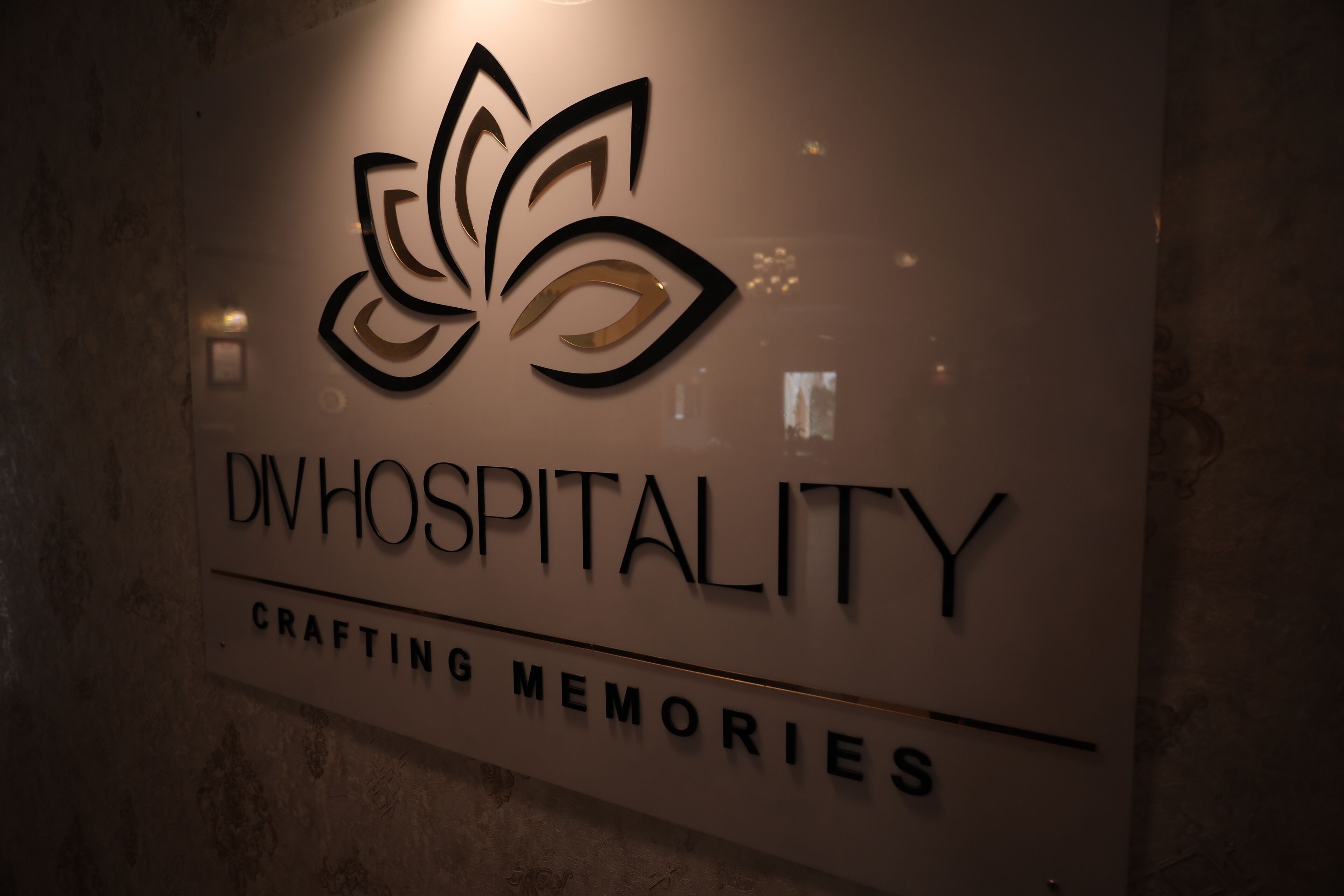 A sign with the text 'DIVHOSPITALITY' and 'CRAFTING MEMORIES' on a wall.