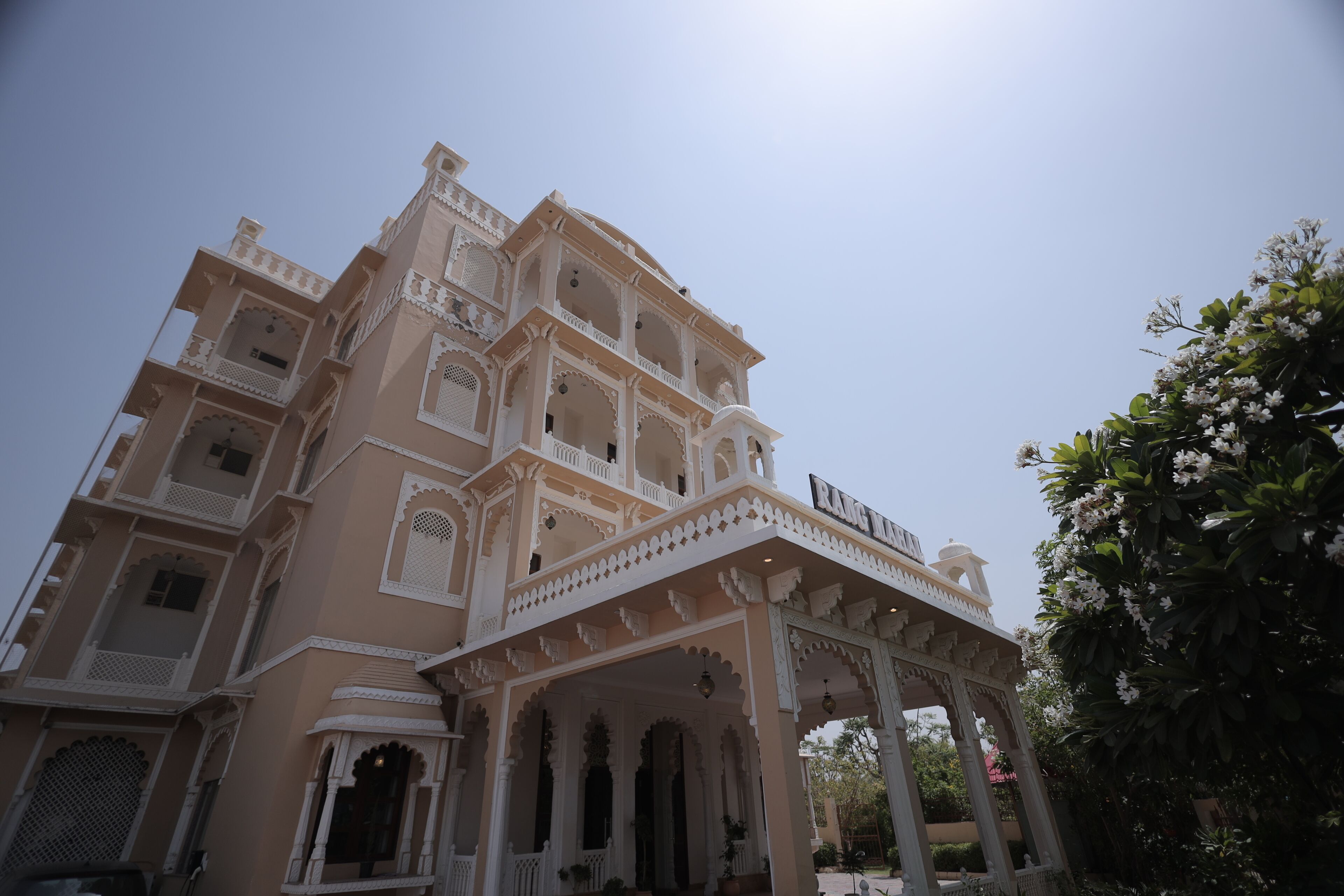 A multi-story building with ornate balconies and a covered entrance.