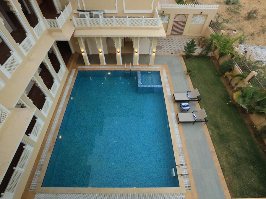 Una piscina cubierta, una piscina al aire libre, tumbonas
