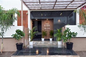 The entrance of Hotel Grand Ecotel with a modern design, featuring a checkered floor, potted plants, and a welcoming sign. - Hotel Grand Ecotel (Chhatrapati Sambhajinagar)