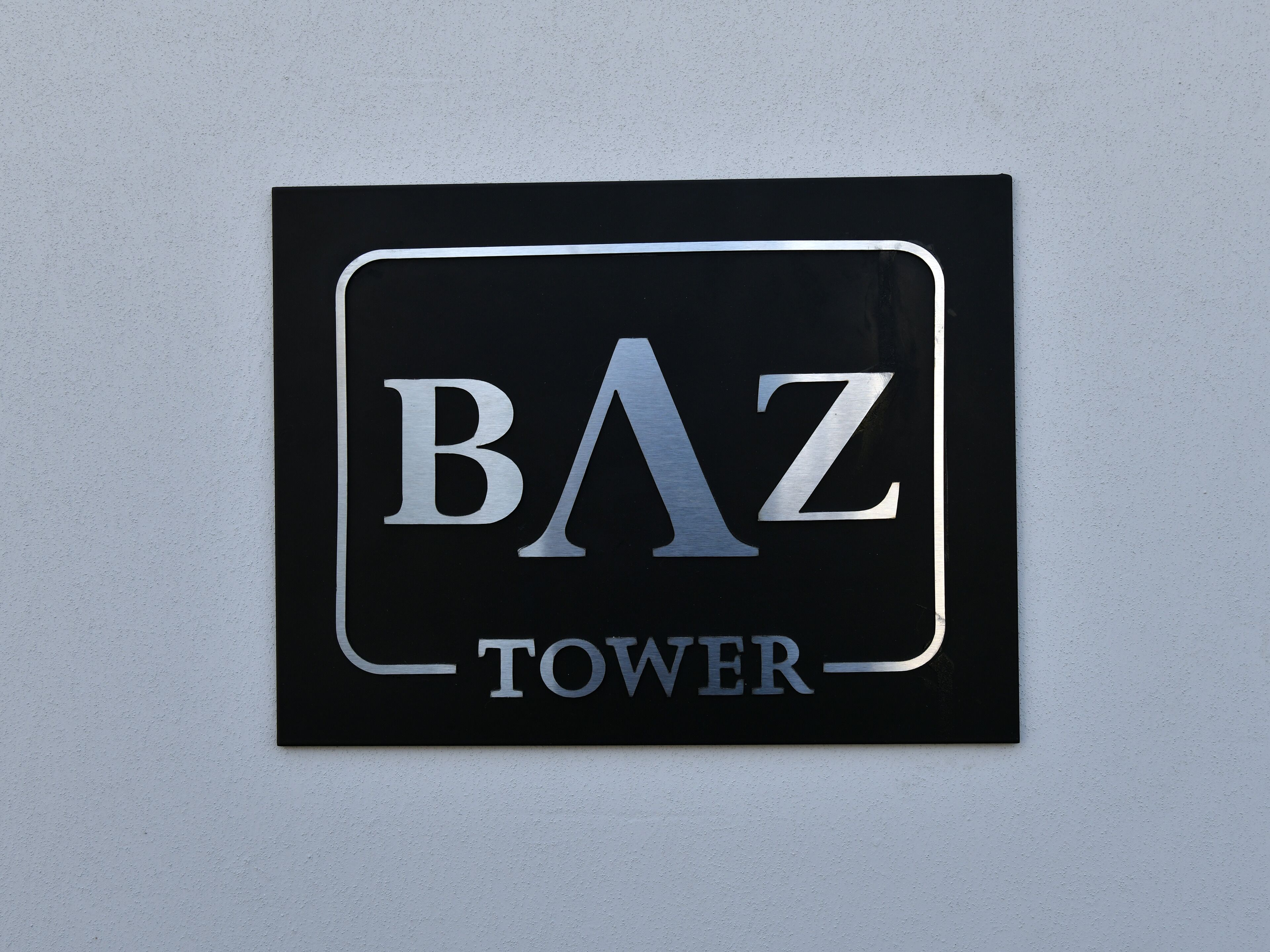 A sign with the text "BAZ TOWER".