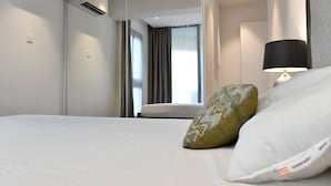 Quarto de hotel com cama, luminária e ar condicionado.