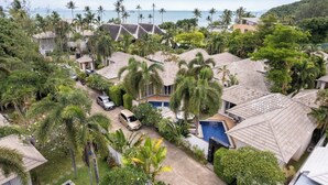 A residential area with houses, a swimming pool, and a view of the ocean.