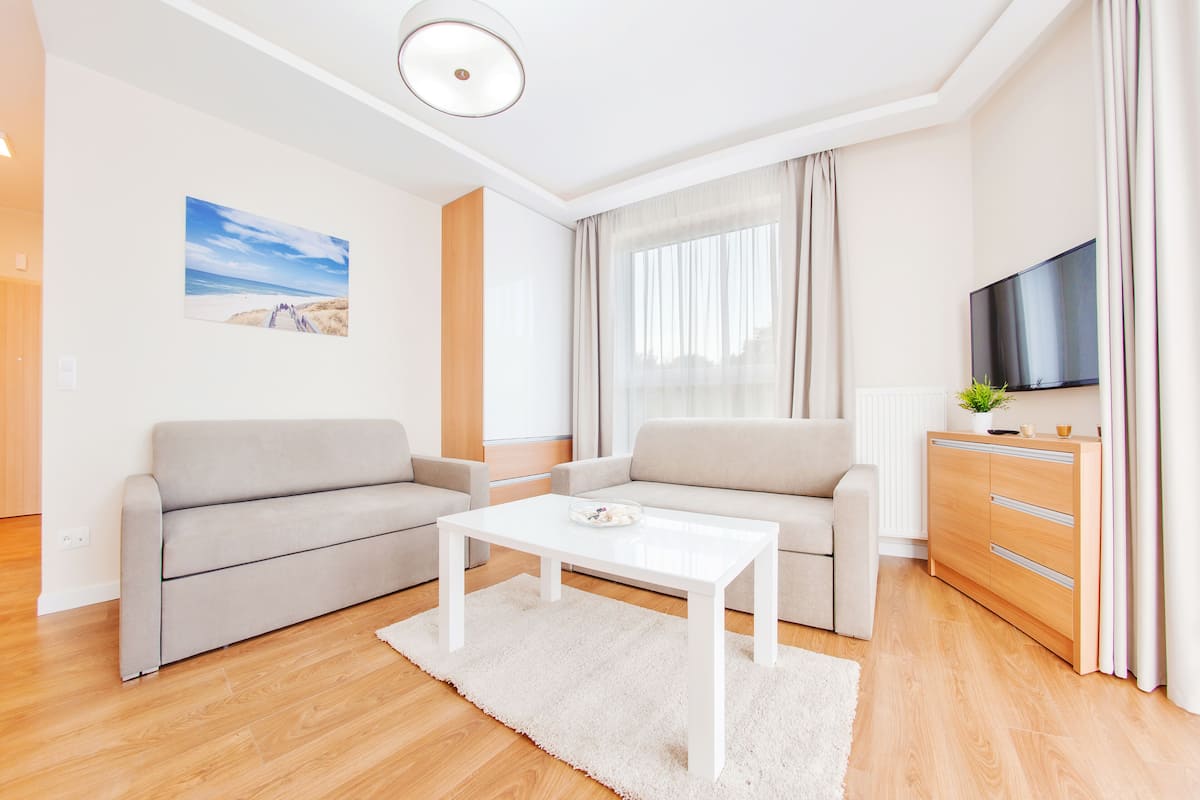 A modern living room with a sofa, a coffee table, a TV, and a cabinet.