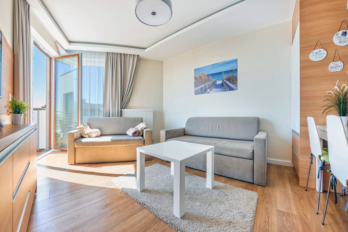 A modern living room with a sofa, a coffee table, and a painting on the wall.