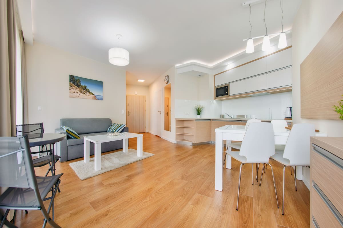 A modern apartment with a living room, dining area, and kitchen.