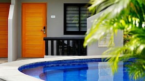 A swimming pool with a tiled edge, a wooden door, and a window with blinds. - Mayfair Resort (Panglao)