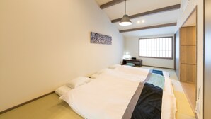 Une chambre à coucher avec un lit, une table de chevet, une lampe et une fenêtre.