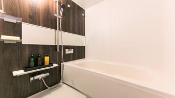 A modern bathroom with a wooden wall, a white bathtub, and a showerhead.